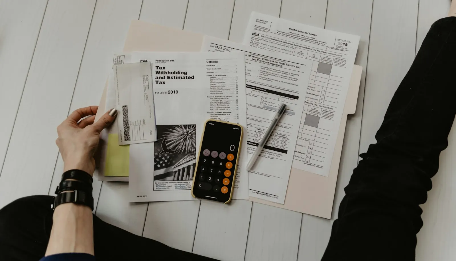 Financial forms, calculator and pen on a desk